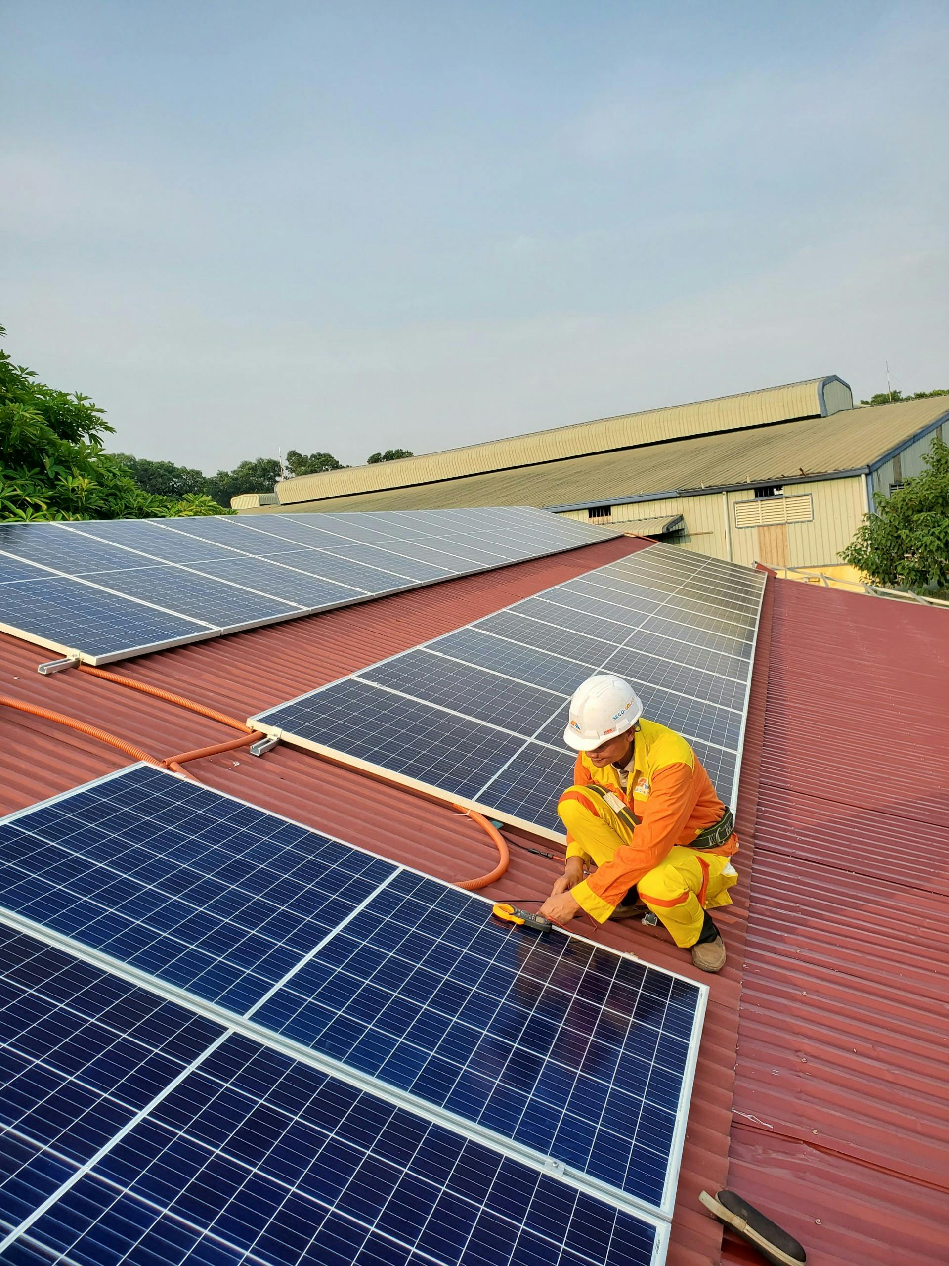 Man installing solar panels on a roof